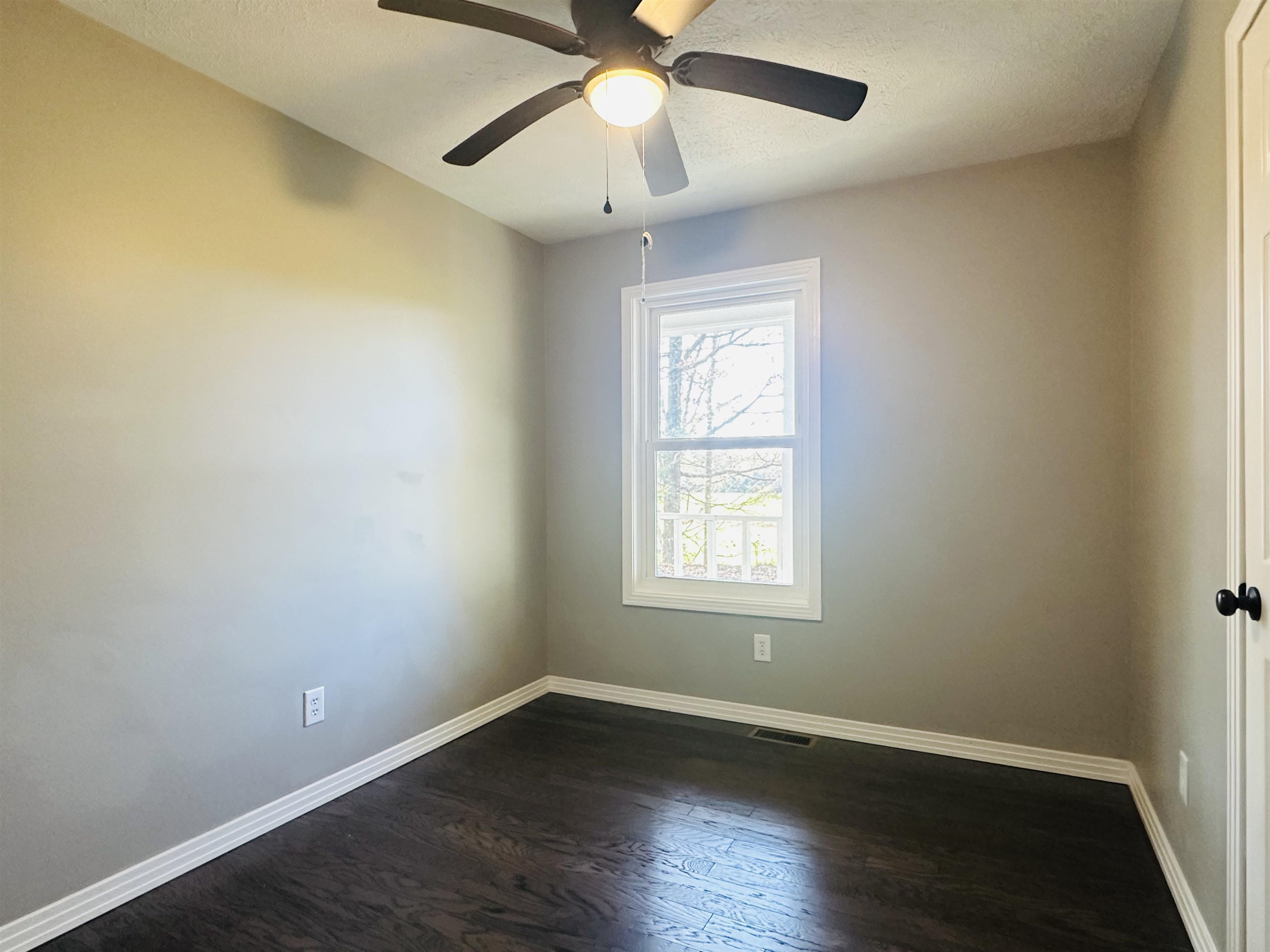 623 Bethesda-Purdy Road Selmer, TN 38375 - Photo 15 of 19 Empty room featuring a textured ceiling, dark hardwood / wood-style flooring, and ceiling fan