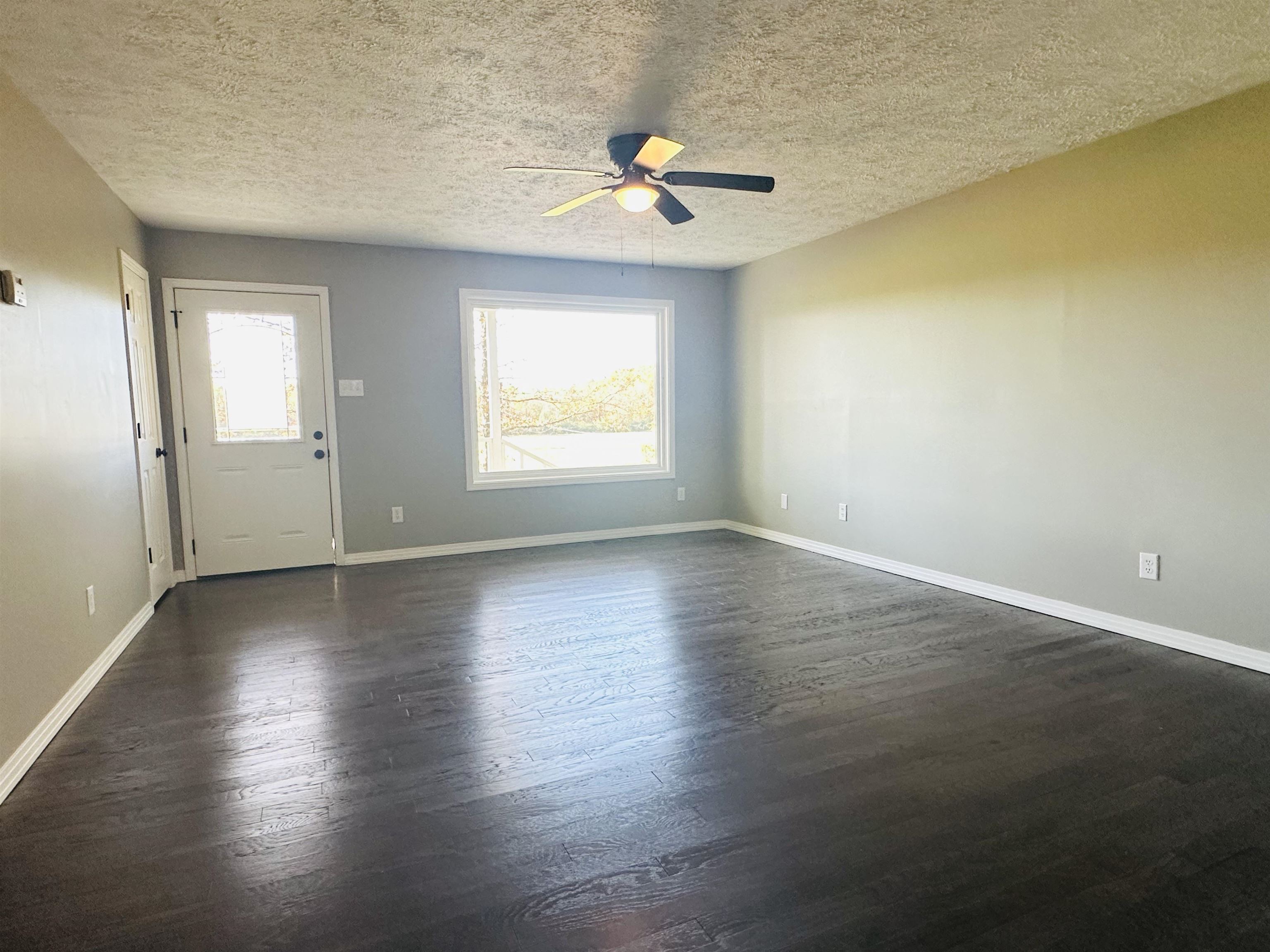623 Bethesda-Purdy Road Selmer, TN 38375 - Photo 2 of 19 Spare room with a textured ceiling, ceiling fan, and dark wood-type flooring