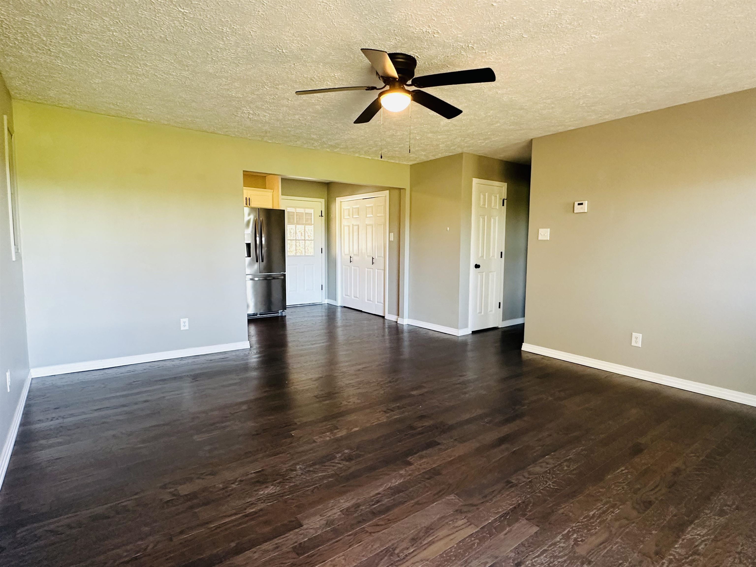 623 Bethesda-Purdy Road Selmer, TN 38375 - Photo 4 of 19 Unfurnished room featuring dark hardwood / wood-style floors, ceiling fan, and a textured ceiling