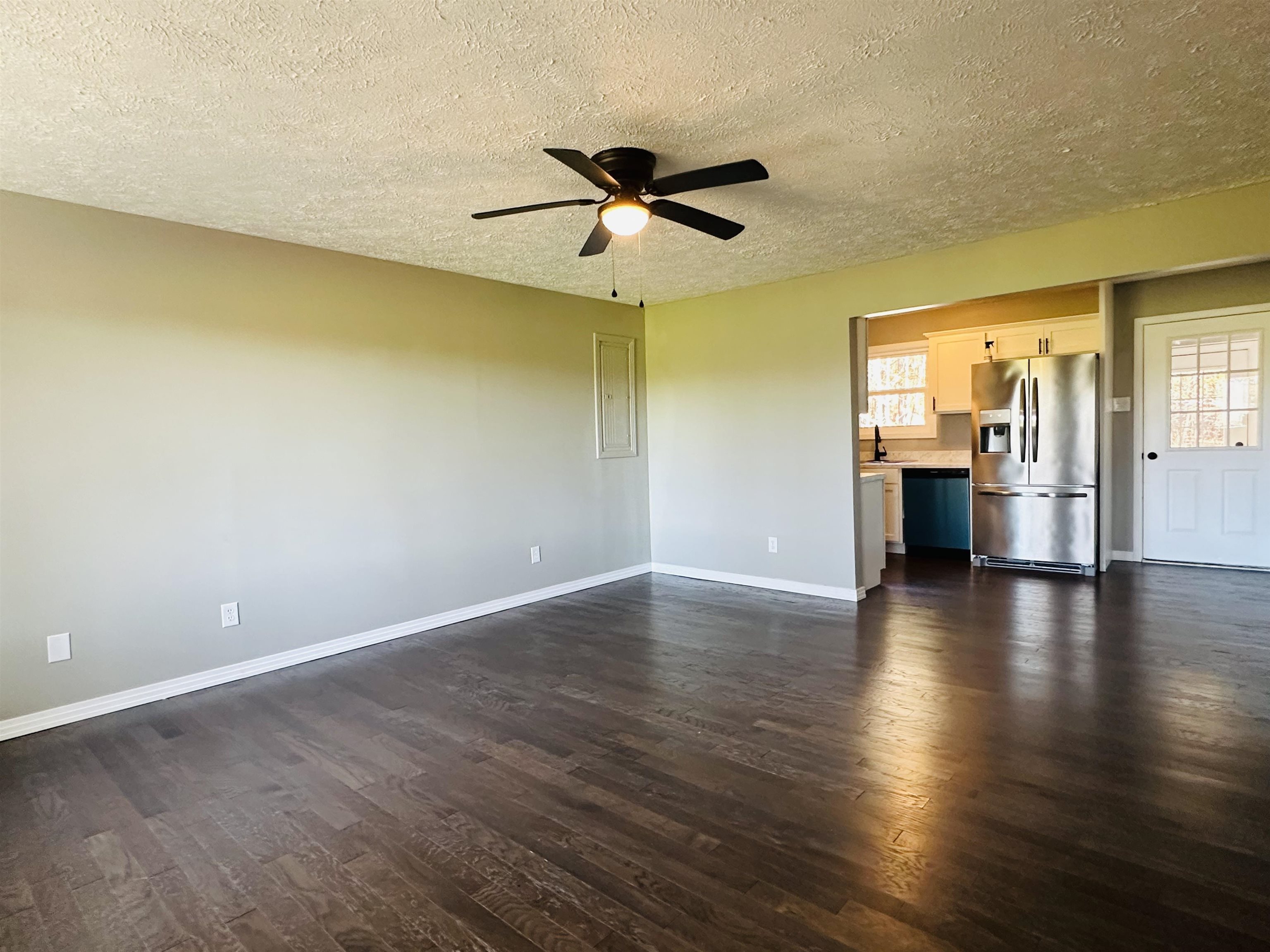 623 Bethesda-Purdy Road Selmer, TN 38375 - Photo 5 of 19 Unfurnished living room featuring a textured ceiling, dark hardwood / wood-style floors, ceiling fan, and sink