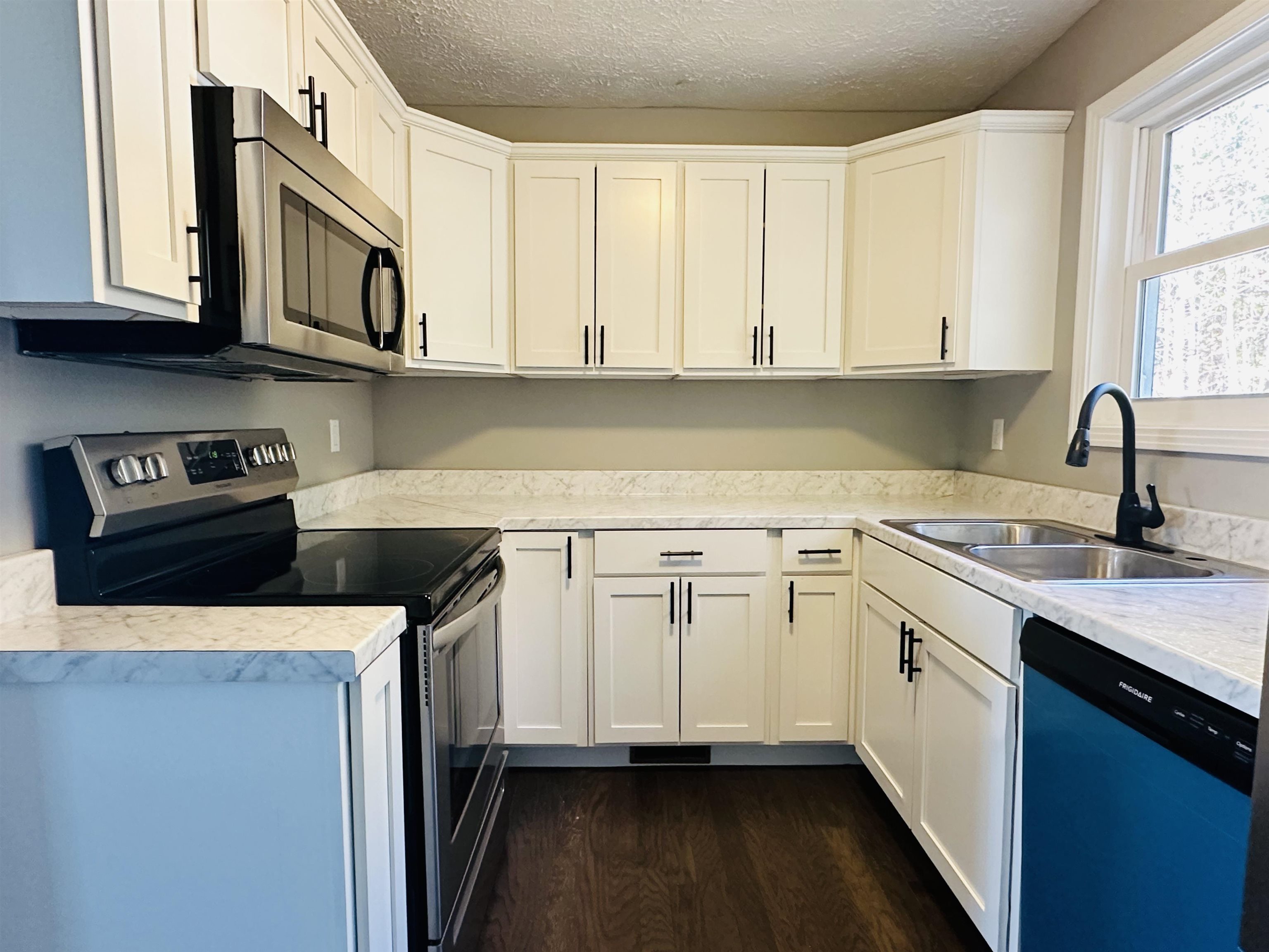 623 Bethesda-Purdy Road Selmer, TN 38375 - Photo 6 of 19 Kitchen with dark wood-type flooring, white cabinets, sink, a textured ceiling, and appliances with stainless steel finishes