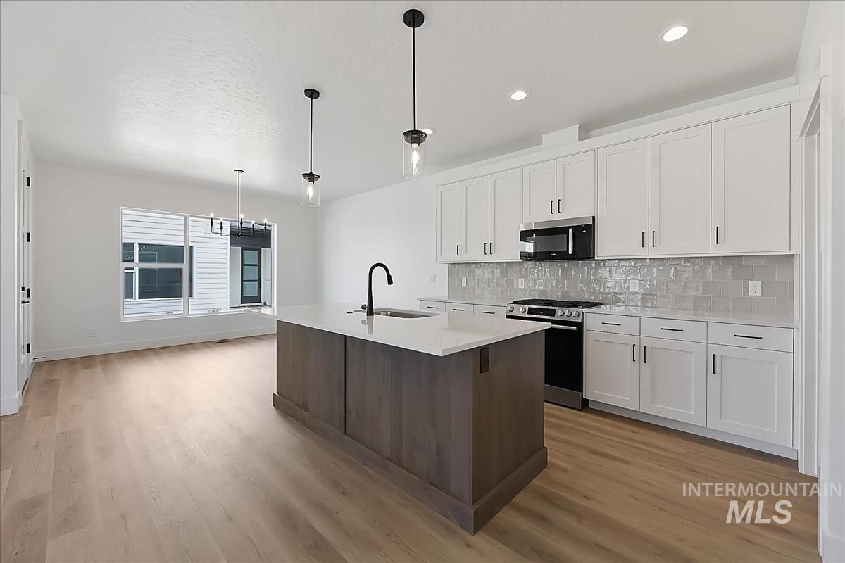 776 South Calhoun Lane Star, ID 83669 - Photo 1 of 49 Modern kitchen featuring white shaker cabinetry, stainless steel appliances, and a light gray subway tile backsplash