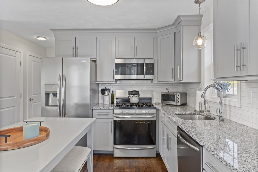 45 Riley Road, Unit 45 Tyngsborough, MA 01879 - Photo 12 of 42 a kitchen with stainless steel appliances granite countertop a stove refrigerator sink and cabinets