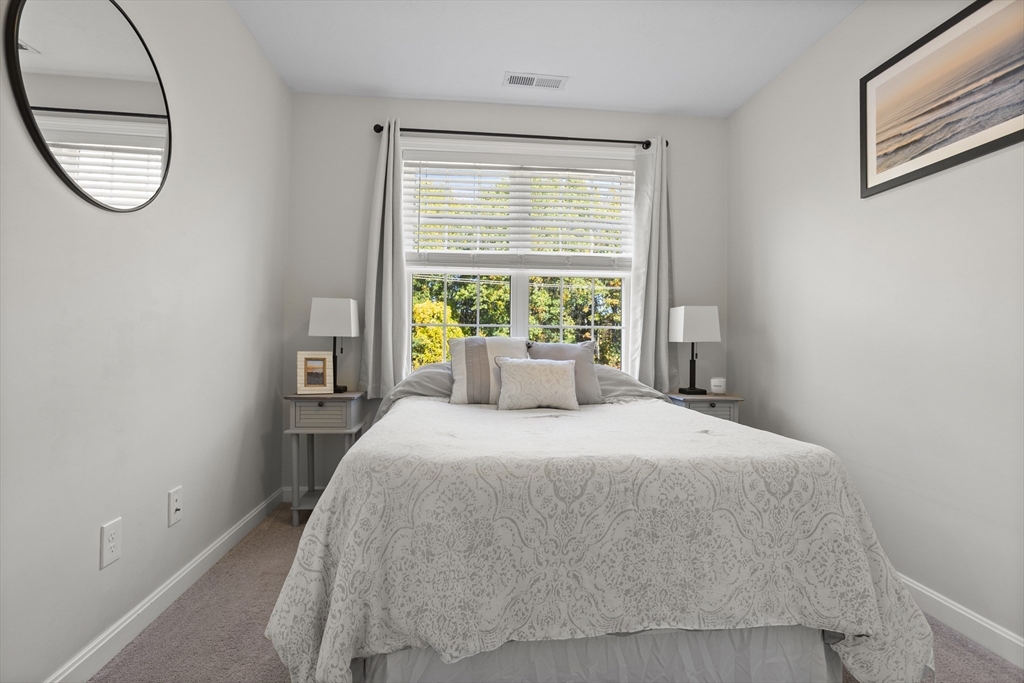 45 Riley Road, Unit 45 Tyngsborough, MA 01879 - Photo 18 of 42 a bedroom with a bed a mirror and a window