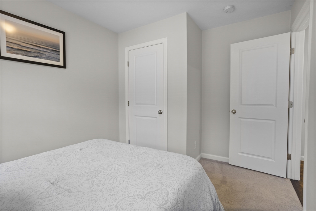 45 Riley Road, Unit 45 Tyngsborough, MA 01879 - Photo 19 of 42 a bedroom with a bed and painting on the wall