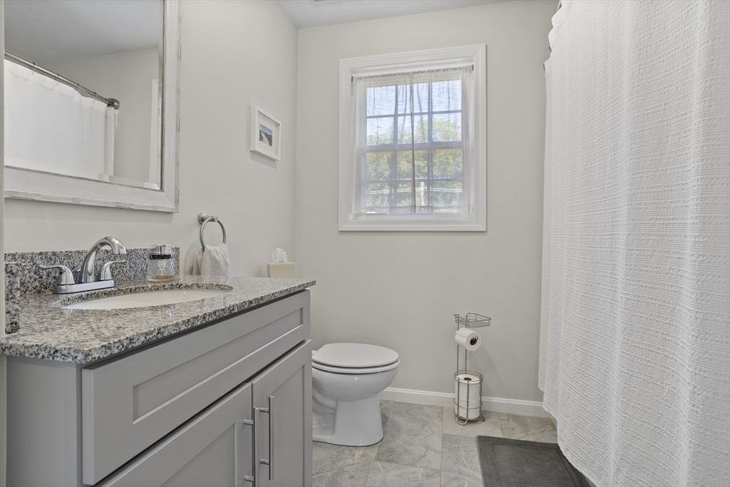 45 Riley Road, Unit 45 Tyngsborough, MA 01879 - Photo 20 of 42 a bathroom with a granite countertop toilet sink and mirror