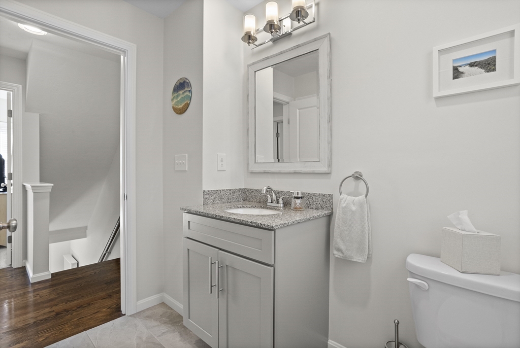45 Riley Road, Unit 45 Tyngsborough, MA 01879 - Photo 21 of 42 a bathroom with a granite countertop sink a toilet and a mirror