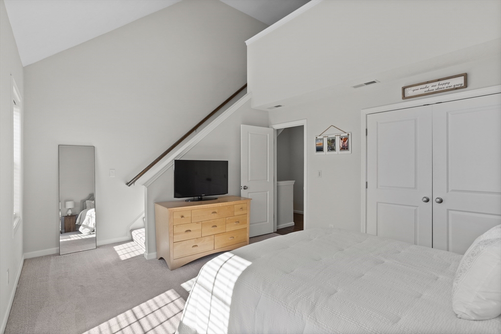 45 Riley Road, Unit 45 Tyngsborough, MA 01879 - Photo 25 of 42 a bedroom with a bed and a flat tv screen on wall