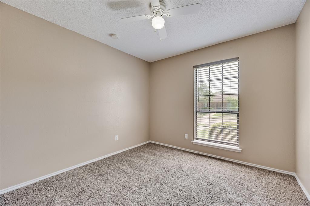 7805 Swiss Way Rowlett, TX 75089 - Photo 24 of 32 an empty room with a chandelier fan and windows