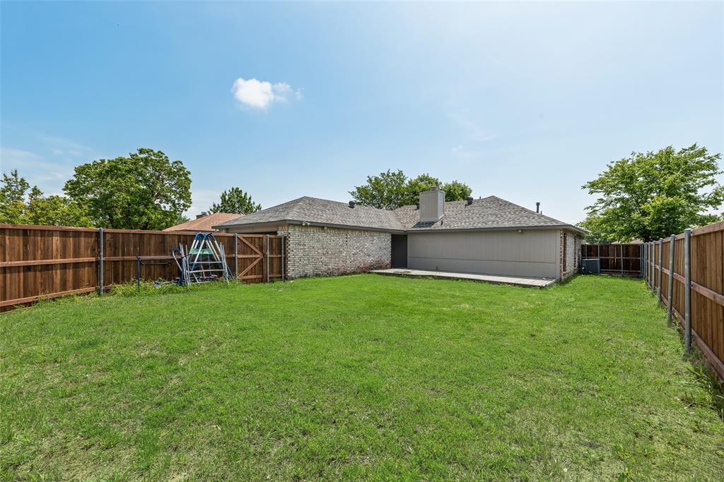 7805 Swiss Way Rowlett, TX 75089 - Photo 32 of 32 a view of a backyard with potted plants and wooden fence