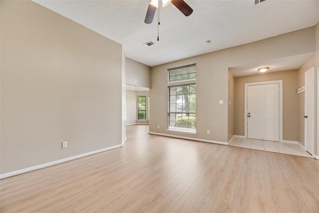 7805 Swiss Way Rowlett, TX 75089 - Photo 6 of 32 an empty room with wooden floor chandelier fan and windows
