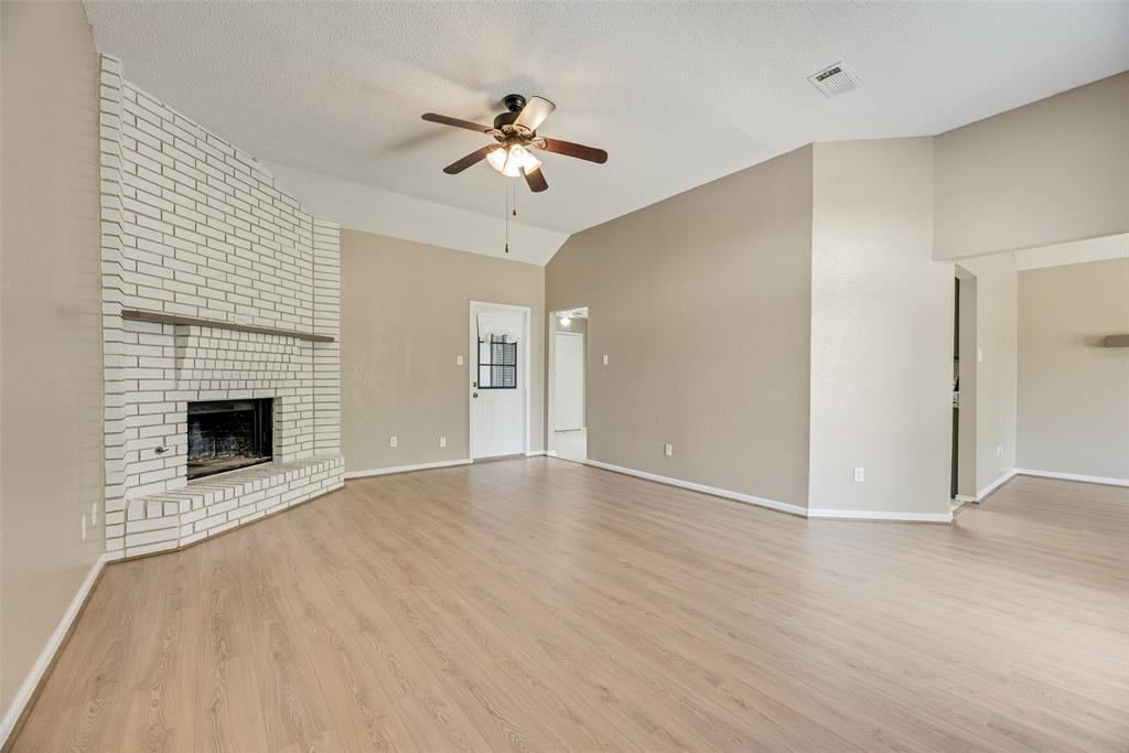 7805 Swiss Way Rowlett, TX 75089 - Photo 7 of 32 a view of an empty room with wooden floor fireplace and a window