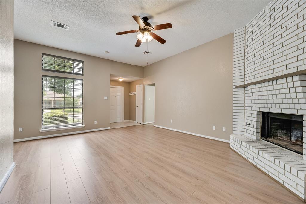 7805 Swiss Way Rowlett, TX 75089 - Photo 9 of 32 an empty room with wooden floor a chandelier fan and windows