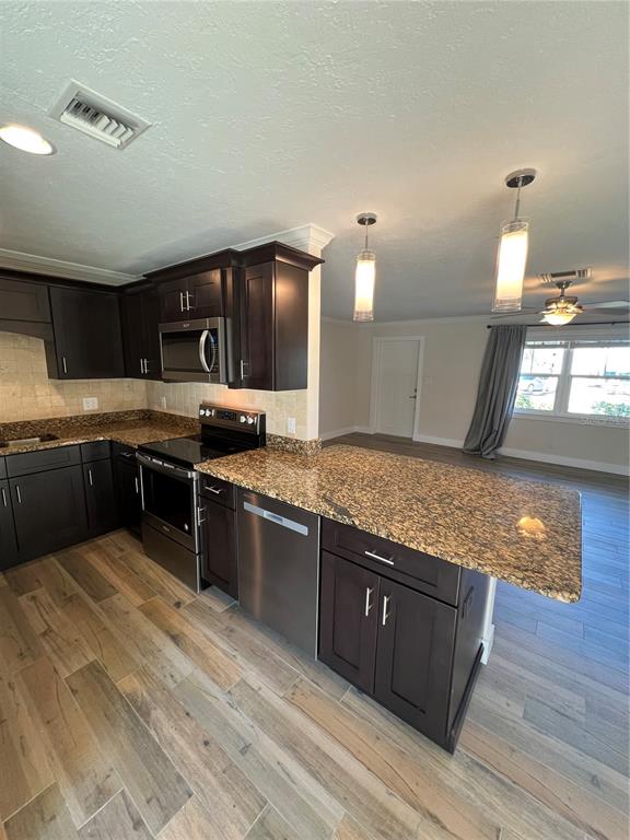 511 West Retta Esplanade Punta Gorda, FL 33950 - Photo 9 of 19 a kitchen with stainless steel appliances granite countertop a stove a sink and a microwave