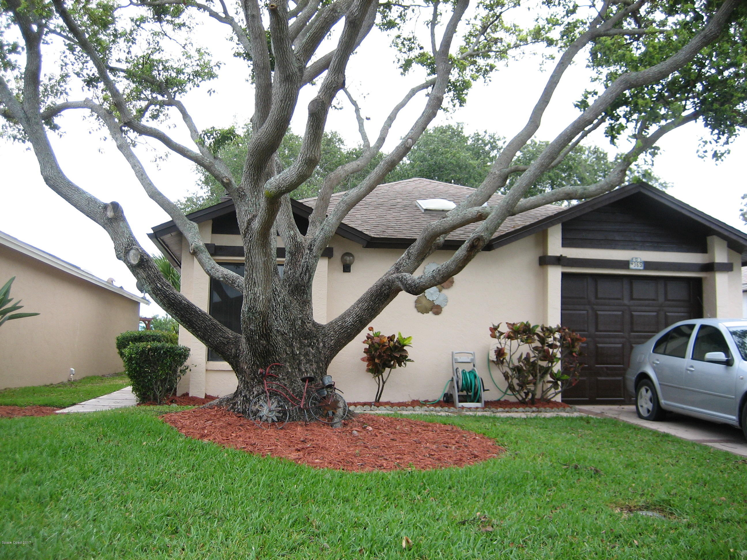 365 Myrtlewood Road Melbourne, FL 32940 - Photo 2 of 8 a view of backyard with table and chairs potted plants and a large tree