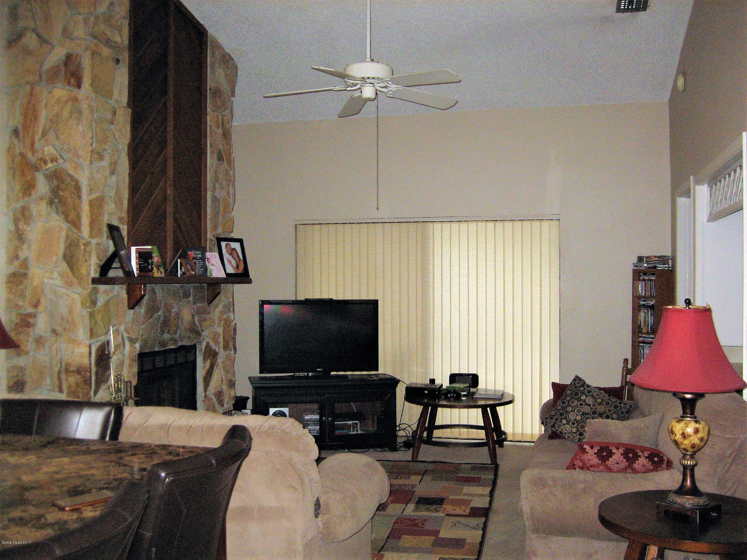 365 Myrtlewood Road Melbourne, FL 32940 - Photo 3 of 8 a living room with furniture a flat screen tv and a fireplace