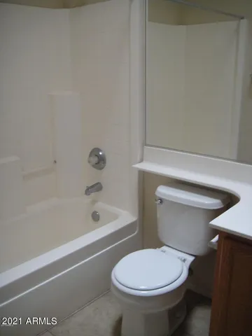 a white toilet sitting next to a bath tub