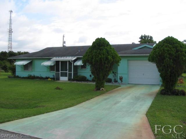 112 Idaho Road Lehigh Acres, FL 33936 - Photo 1 of 1 a front view of a house with a garden