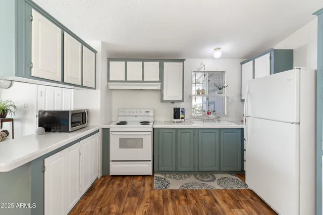 a kitchen with a sink a refrigerator a microwave and cabinets
