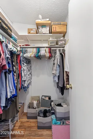 a view of walk in closet with clothes and shoes