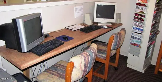 a workspace with furniture and screen on the wall