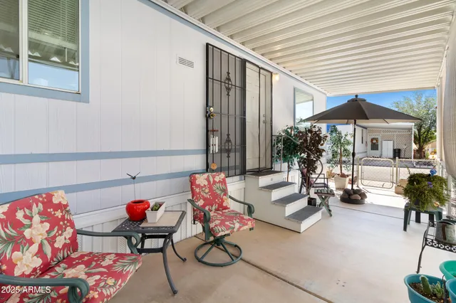 a view of a patio with table and chairs under an umbrella