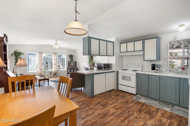 a kitchen with a table chairs a sink dishwasher window and cabinets