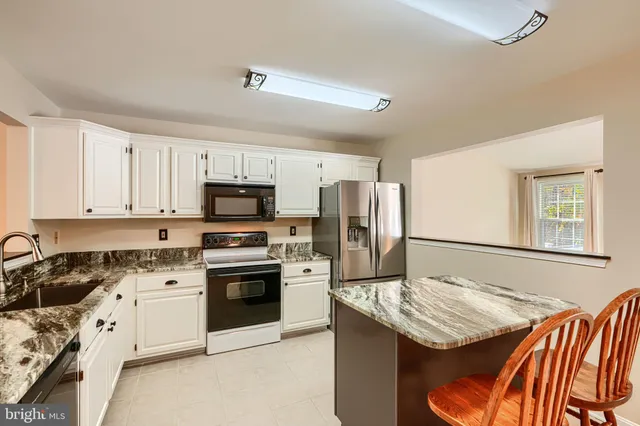 a kitchen with stainless steel appliances granite countertop a stove refrigerator sink and cabinets
