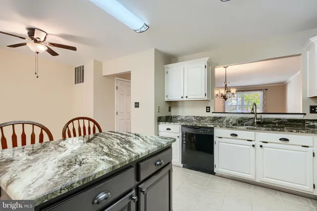 a kitchen with granite countertop white cabinets and appliances
