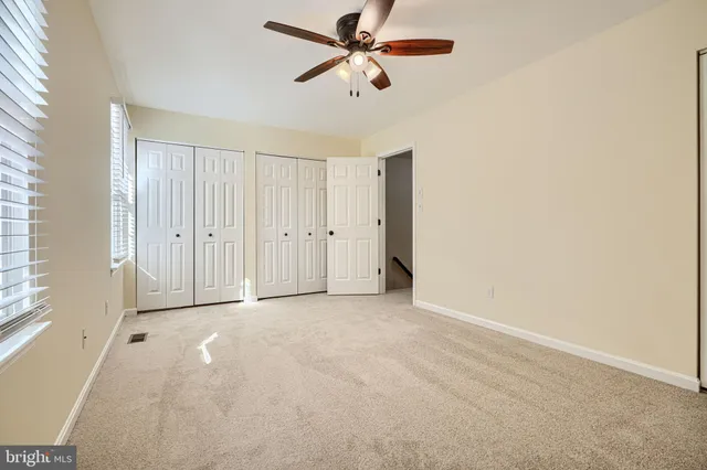 an empty room with chandelier fan