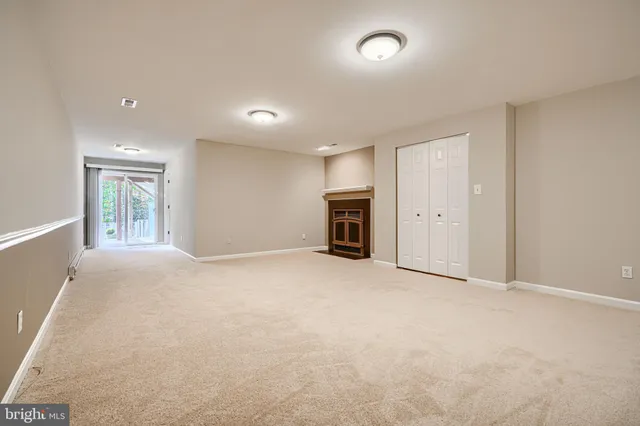 an empty room with fireplace and a window