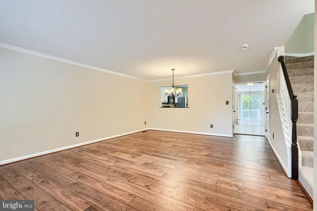a view of empty room with wooden floor and window