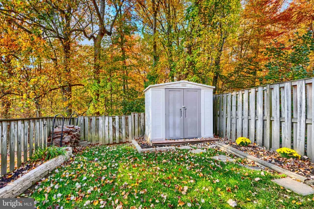a fire hydrant in front of a wooden fence