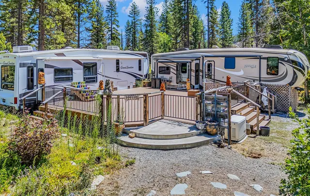 a view of a white house with large windows and a table and chairs