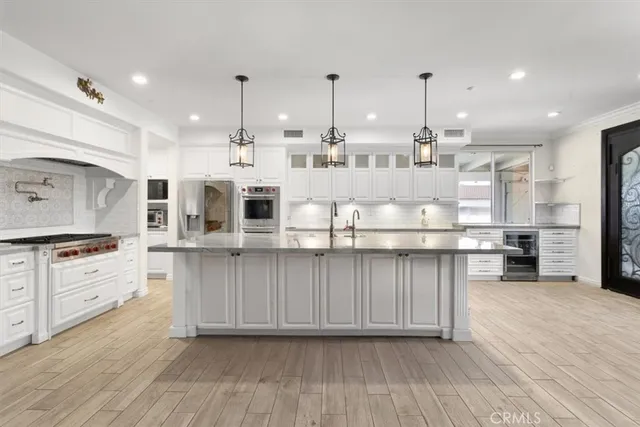 a kitchen with stainless steel appliances granite countertop a stove a sink and white cabinets