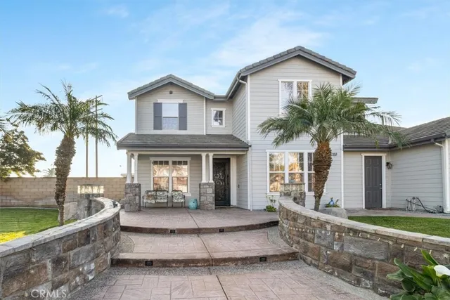 a front view of a house with a yard and potted plants