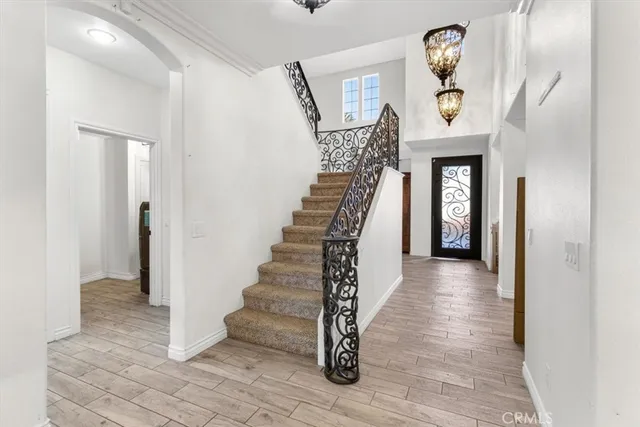 a view of an empty room with a chandelier fan