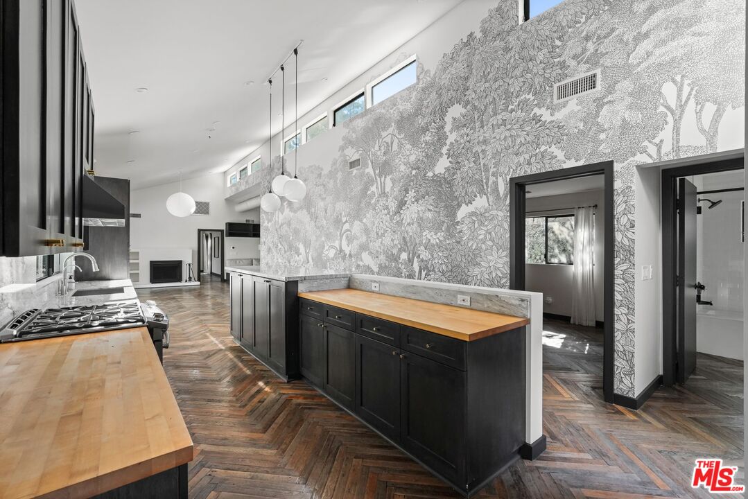 21273 Entrada Road Topanga, CA 90290 - Photo 25 of 70 a large kitchen with stainless steel appliances granite countertop a sink dishwasher stove and oven with wooden floor
