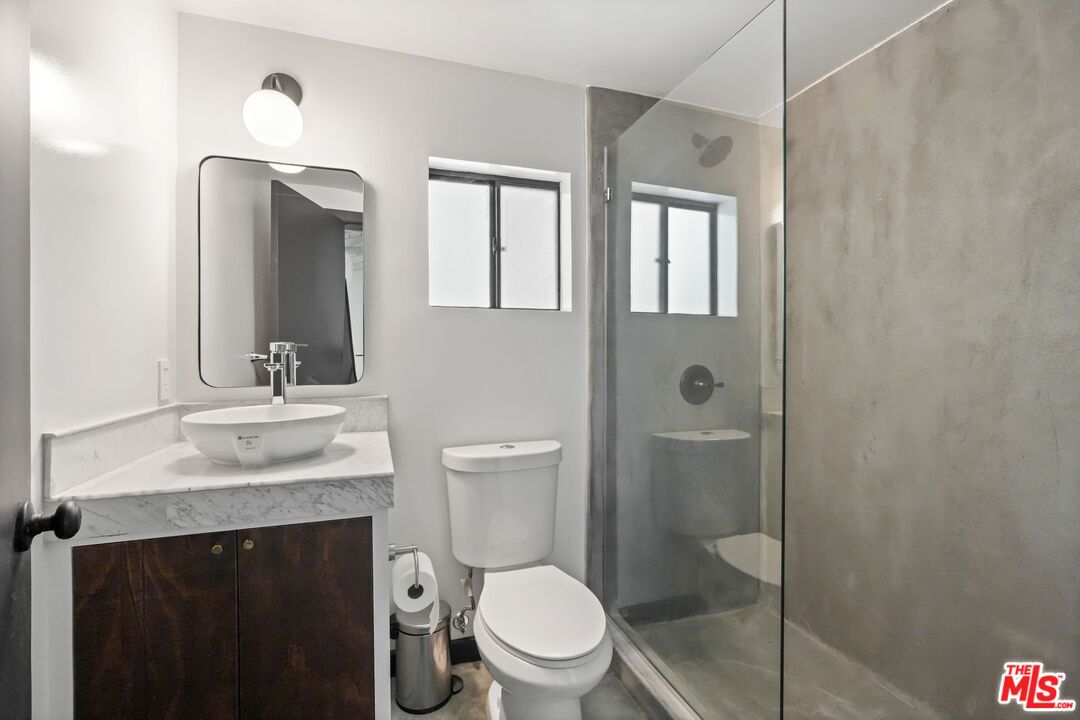 21273 Entrada Road Topanga, CA 90290 - Photo 63 of 70 a bathroom with a granite countertop sink toilet and shower