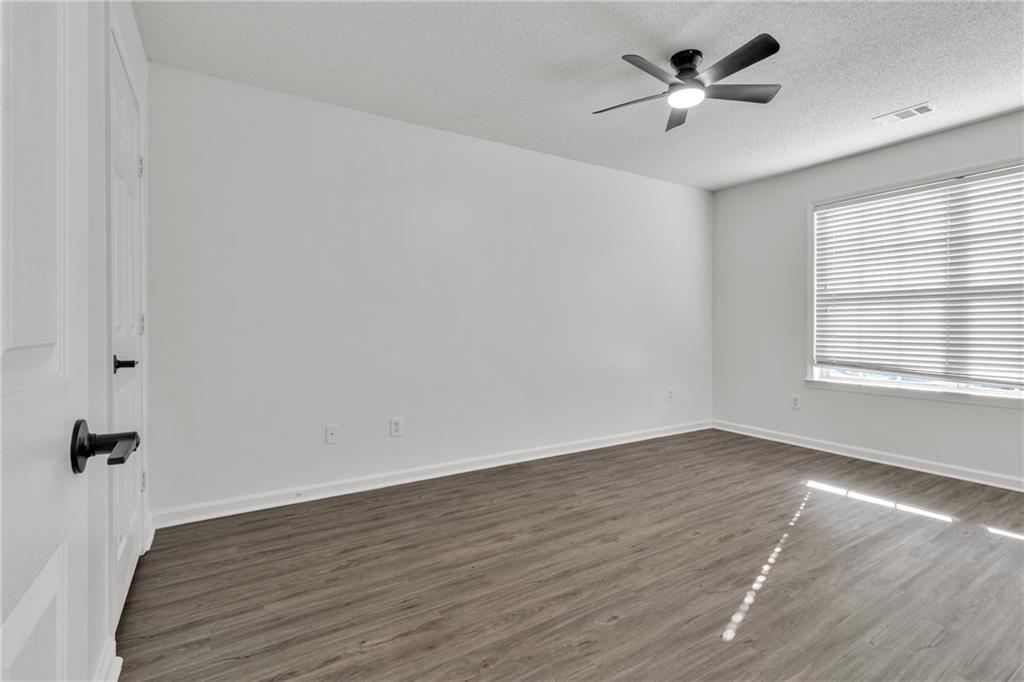 9155 Nesbit Ferry Road, Unit 96 Alpharetta, GA 30022 - Photo 26 of 46 an empty room with wooden floor and windows