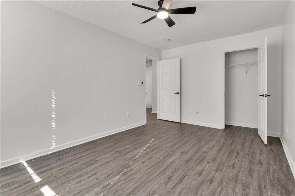 9155 Nesbit Ferry Road, Unit 96 Alpharetta, GA 30022 - Photo 27 of 46 an empty room with wooden floor fan and windows