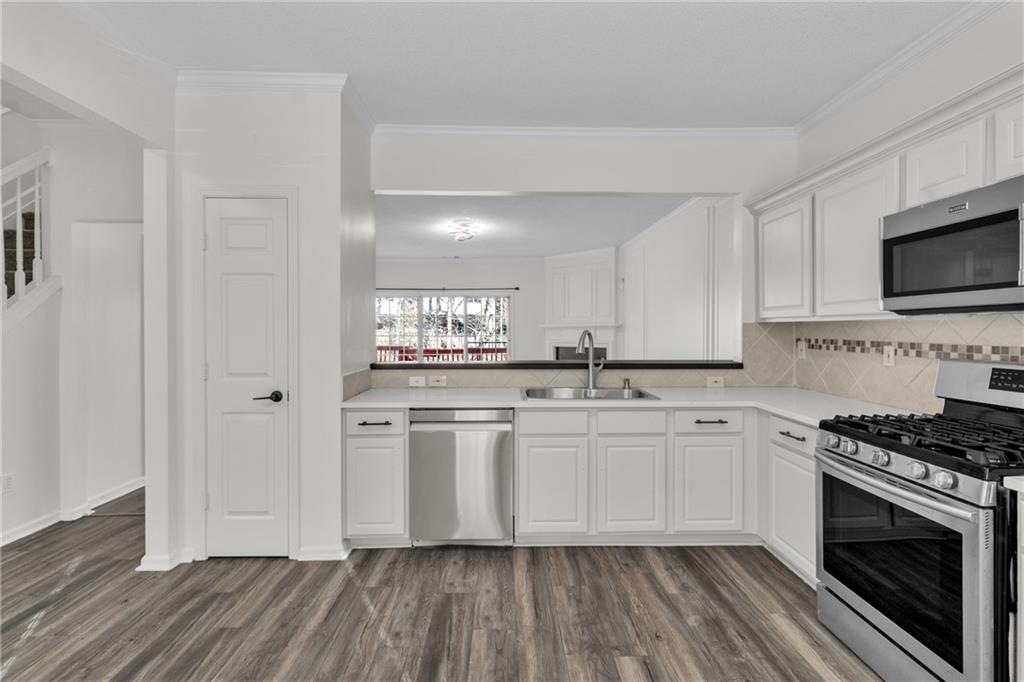 9155 Nesbit Ferry Road, Unit 96 Alpharetta, GA 30022 - Photo 7 of 46 a kitchen with stainless steel appliances a stove a sink and a microwave