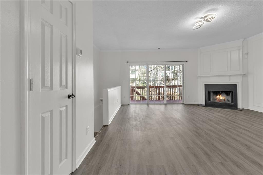9155 Nesbit Ferry Road, Unit 96 Alpharetta, GA 30022 - Photo 9 of 46 a view of an empty room with wooden floor and a window