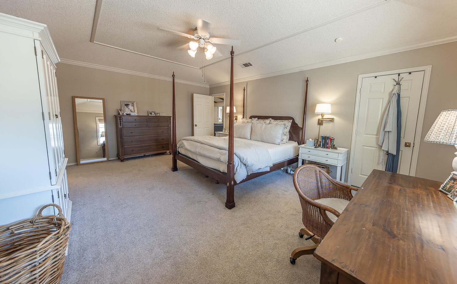 4411 88th Street Lubbock, TX 79424 - Photo 16 of 38 a spacious bedroom with a bed and a chandelier