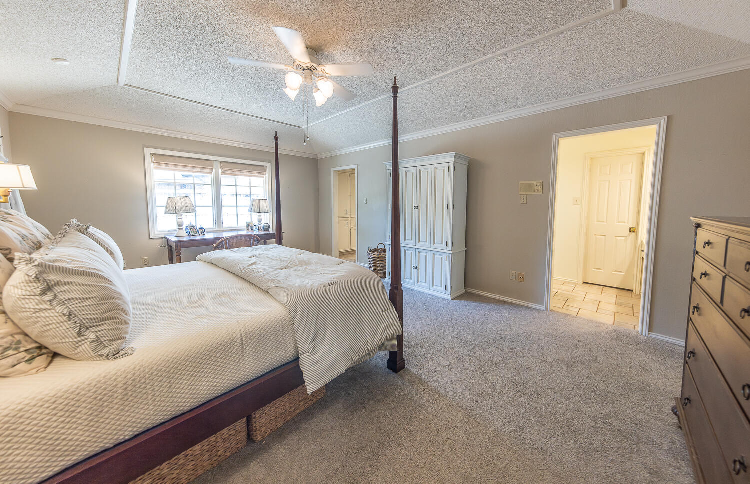 4411 88th Street Lubbock, TX 79424 - Photo 17 of 38 a bedroom with a bed and a chandelier