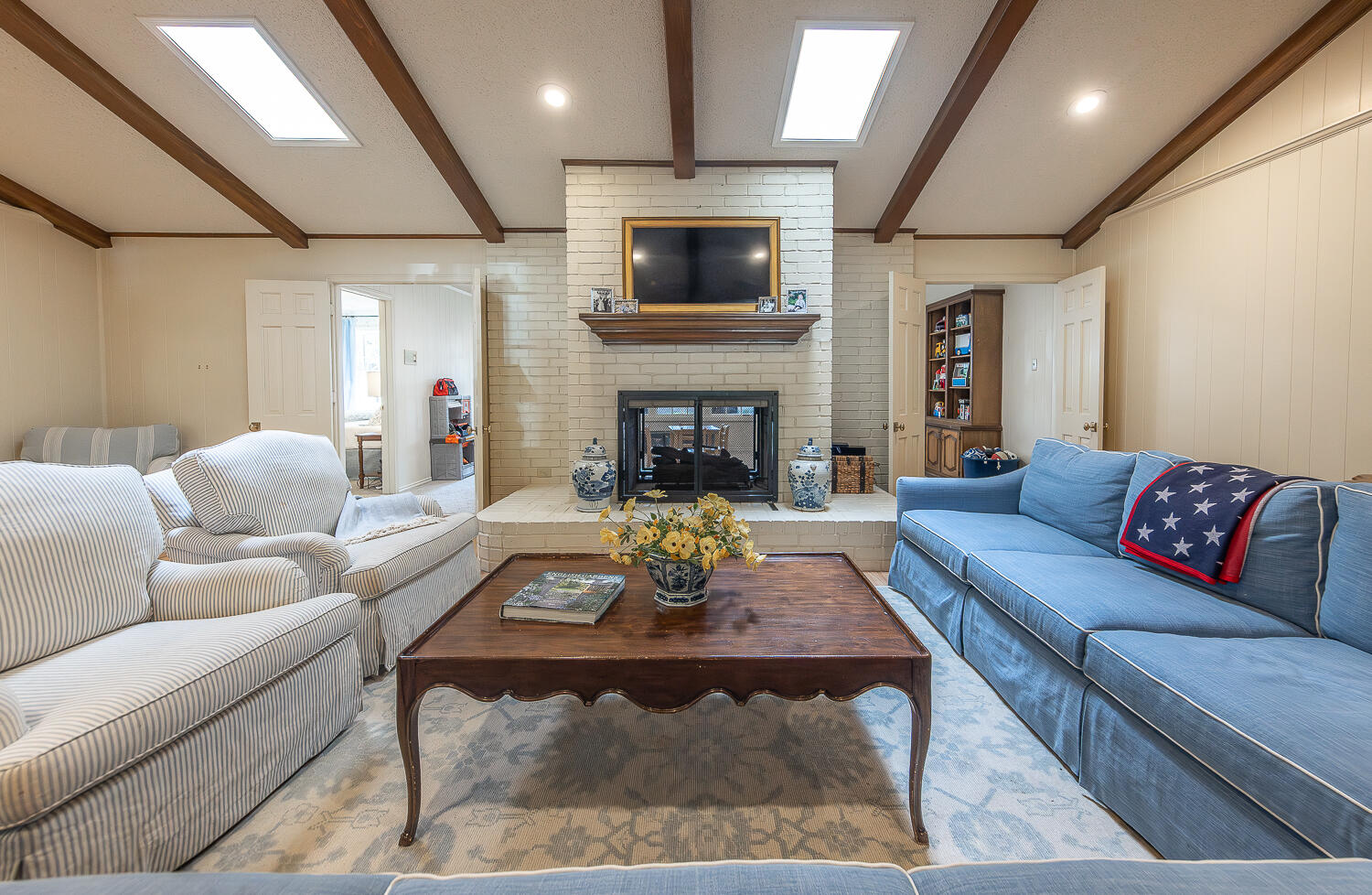 4411 88th Street Lubbock, TX 79424 - Photo 2 of 38 a living room with furniture a fireplace and a flat screen tv