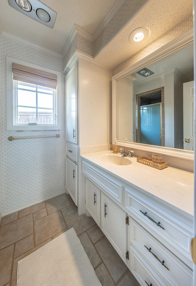 4411 88th Street Lubbock, TX 79424 - Photo 27 of 38 a bathroom with a sink and a mirror