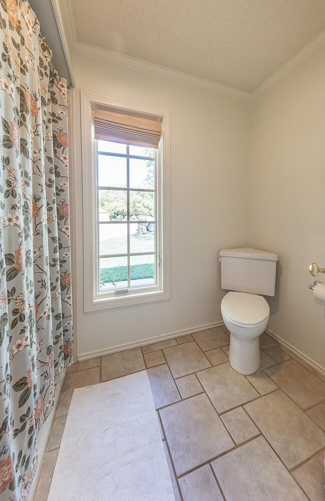 4411 88th Street Lubbock, TX 79424 - Photo 29 of 38 a bathroom with a toilet a window and a window