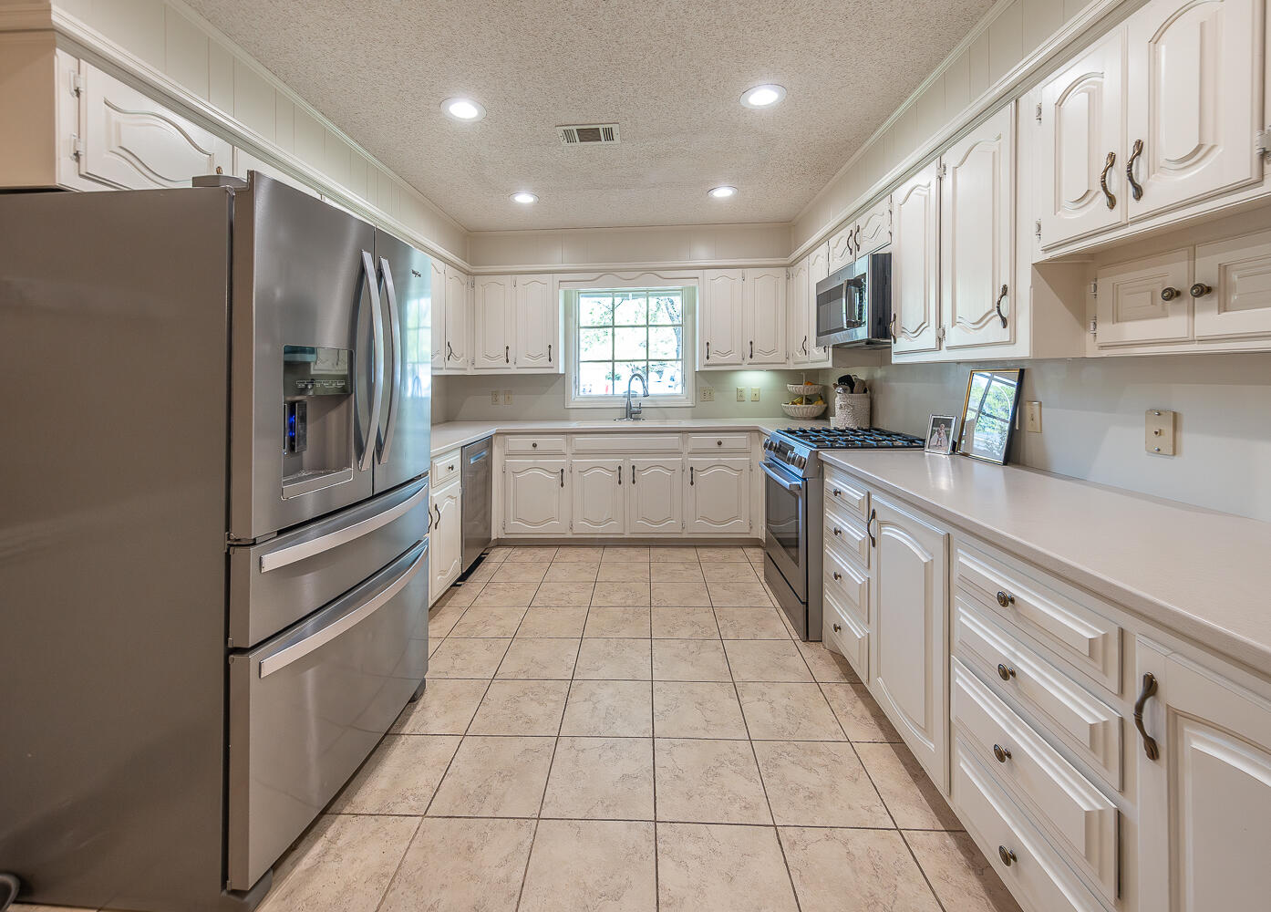 4411 88th Street Lubbock, TX 79424 - Photo 3 of 38 a kitchen with stainless steel appliances granite countertop a refrigerator and a stove top oven