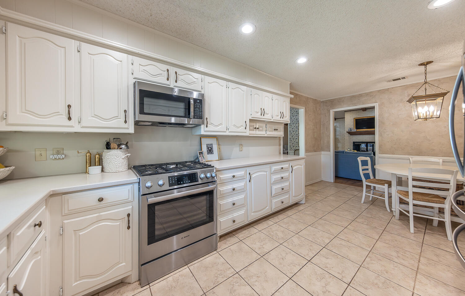 4411 88th Street Lubbock, TX 79424 - Photo 9 of 38 a kitchen with white cabinets and appliances